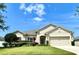Charming single-story home featuring a well-manicured lawn, neutral color palette, and a two-car garage at 865 Bay Bridge Cir, Apopka, FL 32703