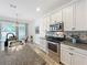 Modern kitchen featuring stainless steel appliances, a stylish backsplash, and a view of the dining space at 865 Bay Bridge Cir, Apopka, FL 32703