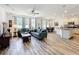 Open-concept living room with wood-look tile, modern ceiling fan, and adjacent kitchen at 865 Bay Bridge Cir, Apopka, FL 32703