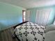 Cozy bedroom featuring neutral walls, wood flooring, and a patterned quilt on the bed at 951 Cr 453, Lake Panasoffkee, FL 33538