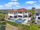 An aerial view of the home's resort-style backyard with a gorgeous pool, hot tub and sun loungers at 971 Golden Bear Dr, Reunion, FL 34747