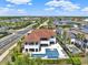 Stunning aerial view of a luxury home with a terracotta roof, large pool, and lush landscaping in a beautiful neighborhood at 971 Golden Bear Dr, Reunion, FL 34747