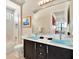 Bright bathroom with blue vessel sinks, dark cabinets, and tiled shower with glass door for a spa-like experience at 971 Golden Bear Dr, Reunion, FL 34747