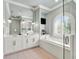Bright bathroom boasts dual sinks, a soaking tub, a glass enclosed shower, and large mirror at 971 Golden Bear Dr, Reunion, FL 34747