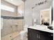 Elegant bathroom featuring glass enclosed shower, dark wood vanity with double sinks, and marble countertops at 971 Golden Bear Dr, Reunion, FL 34747