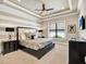 Inviting primary bedroom with a tray ceiling, a large window for natural light and a king-size bed at 971 Golden Bear Dr, Reunion, FL 34747