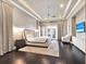 Bright bedroom features a plush rug, tray ceilings, and French doors leading to outdoor space with a comfortable couch at 971 Golden Bear Dr, Reunion, FL 34747