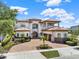 Elegant two-story home with a brick driveway, beautiful landscaping, and a classic Mediterranean-style tile roof at 971 Golden Bear Dr, Reunion, FL 34747