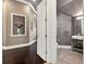 Elegant hallway showcasing dark hardwood floors, decorative wall niche, and a glimpse into the stylishly appointed bathroom at 971 Golden Bear Dr, Reunion, FL 34747