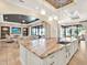 Bright, open floorplan with large kitchen island, sink, seating, and connecting to the living and dining areas at 971 Golden Bear Dr, Reunion, FL 34747