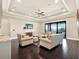 Bright living room offers ample seating, dark hardwood floors, and large sliding glass doors at 971 Golden Bear Dr, Reunion, FL 34747