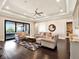 Bright living room offers ample seating, dark hardwood floors, and an elegant tray ceiling at 971 Golden Bear Dr, Reunion, FL 34747