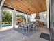Inviting outdoor dining area with a wood ceiling, poolside access, and a built-in grill at 971 Golden Bear Dr, Reunion, FL 34747