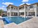 Beautiful backyard with a large pool, built in spa, multiple lounge areas, and a waterfall at 971 Golden Bear Dr, Reunion, FL 34747