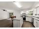 Bright kitchen with white cabinets, stainless steel appliances, a breakfast bar, and a sliding door to the backyard at 992 Woodrose Ct, Altamonte Springs, FL 32714