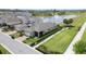 An elevated view of the house shows the green lawn, garden beds, and proximity to a pond at 10006 Quail Meadow Aly, Winter Garden, FL 34787