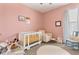 Cozy Bedroom with soft pink walls, white crib, and comfortable rocking chair at 10006 Quail Meadow Aly, Winter Garden, FL 34787