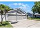 The exterior features a 3 car garage, a basketball hoop and mature landscaping at 1008 W Riviera Blvd, Oviedo, FL 32765