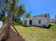 The backyard is spacious with a covered porch and bordered by a modern, white fence with new palm trees at 1096 Happy Forest Loop, Deland, FL 32720