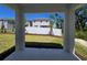 A view from the outdoor porch through to the backyard, showing a white fence, green grass and new landscaping at 1096 Happy Forest Loop, Deland, FL 32720