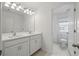 Bright bathroom featuring double sinks, white cabinets, and a separate toilet room, offering convenience and privacy at 1096 Happy Forest Loop, Deland, FL 32720