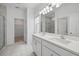 Bathroom featuring double sink vanity, large mirror, glass shower and neutral tile flooring at 1096 Happy Forest Loop, Deland, FL 32720