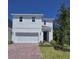 Charming two-story home with a red brick driveway, a two-car garage, and a well-manicured lawn at 1096 Happy Forest Loop, Deland, FL 32720