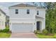 Charming two-story home featuring a two-car garage, brick driveway, and neatly landscaped front yard at 1096 Happy Forest Loop, Deland, FL 32720