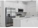 Modern kitchen features stainless steel appliances, white cabinets, quartz countertops, and tile backsplash at 1096 Happy Forest Loop, Deland, FL 32720
