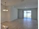 Bright living room with tile flooring, a modern chandelier, and sliding glass doors opening to the backyard at 1096 Happy Forest Loop, Deland, FL 32720