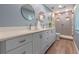 Bright bathroom featuring double sinks, vanity, and tiled glass shower at 1105 Lake Nettie Dr, Eustis, FL 32726