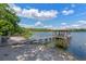 Dock and sandy beach access on a serene lake at 1105 Lake Nettie Dr, Eustis, FL 32726