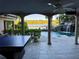 Enjoy the game room overlooking the pool, rock waterfall, and serene lake, blending leisure with natural beauty at 1105 Lake Nettie Dr, Eustis, FL 32726