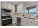 Kitchen view showcasing stainless steel appliances, quartz countertops, and modern white cabinetry at 1105 Lake Nettie Dr, Eustis, FL 32726