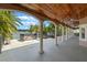 Large covered patio with pillars overlooking the lake, featuring a hot tub and ceiling fan at 1105 Lake Nettie Dr, Eustis, FL 32726