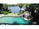 Inviting swimming pool with a waterfall, scenic lake view, and a private boat dock at 1105 Lake Nettie Dr, Eustis, FL 32726