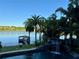 Breathtaking lake view with a charming dock, a rock waterfall feature, and palm trees at 1105 Lake Nettie Dr, Eustis, FL 32726
