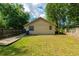 Fenced backyard with green grass, wood pathway and trees at 111 E Caroline St, Tavares, FL 32778