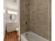 Bathroom featuring tiled shower/tub, modern vanity, new fixtures and wood look flooring at 111 E Caroline St, Tavares, FL 32778