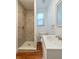 Bathroom with a walk-in tiled shower, modern vanity and fixtures, and wood look flooring at 111 E Caroline St, Tavares, FL 32778
