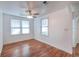This cozy bedroom features wood floors and natural light from the windows at 111 E Caroline St, Tavares, FL 32778