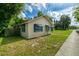 Side view of cozy home featuring a well-manicured lawn and lovely blue awnings at 111 E Caroline St, Tavares, FL 32778