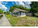 Quaint home featuring a well-maintained lawn and a charming blue awning at 111 E Caroline St, Tavares, FL 32778