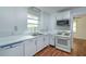 Bright kitchen featuring white cabinets, modern appliances, and wood-look floors at 111 E Caroline St, Tavares, FL 32778