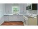 Bright kitchen featuring white cabinets, updated appliances, and a window view at 111 E Caroline St, Tavares, FL 32778
