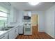 Bright kitchen featuring white cabinets, countertops, updated appliances, and view to other rooms at 111 E Caroline St, Tavares, FL 32778