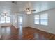 Bright living room featuring hardwood floors, ceiling fan, and plentiful natural light from large windows at 111 E Caroline St, Tavares, FL 32778