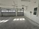 The interior shot shows a clean and spacious two-car garage with white walls, gray floors, and paneled doors at 1157 Basalt Ln, Sanford, FL 32771