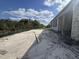 Large backyard with green grass, trees, a fence and the rear of a block home under construction at 1161 Basalt Ln, Sanford, FL 32771