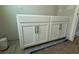 Bathroom vanity with white shaker cabinets, dark bronze hardware, gray floor tile, and light gray walls at 1161 Basalt Ln, Sanford, FL 32771